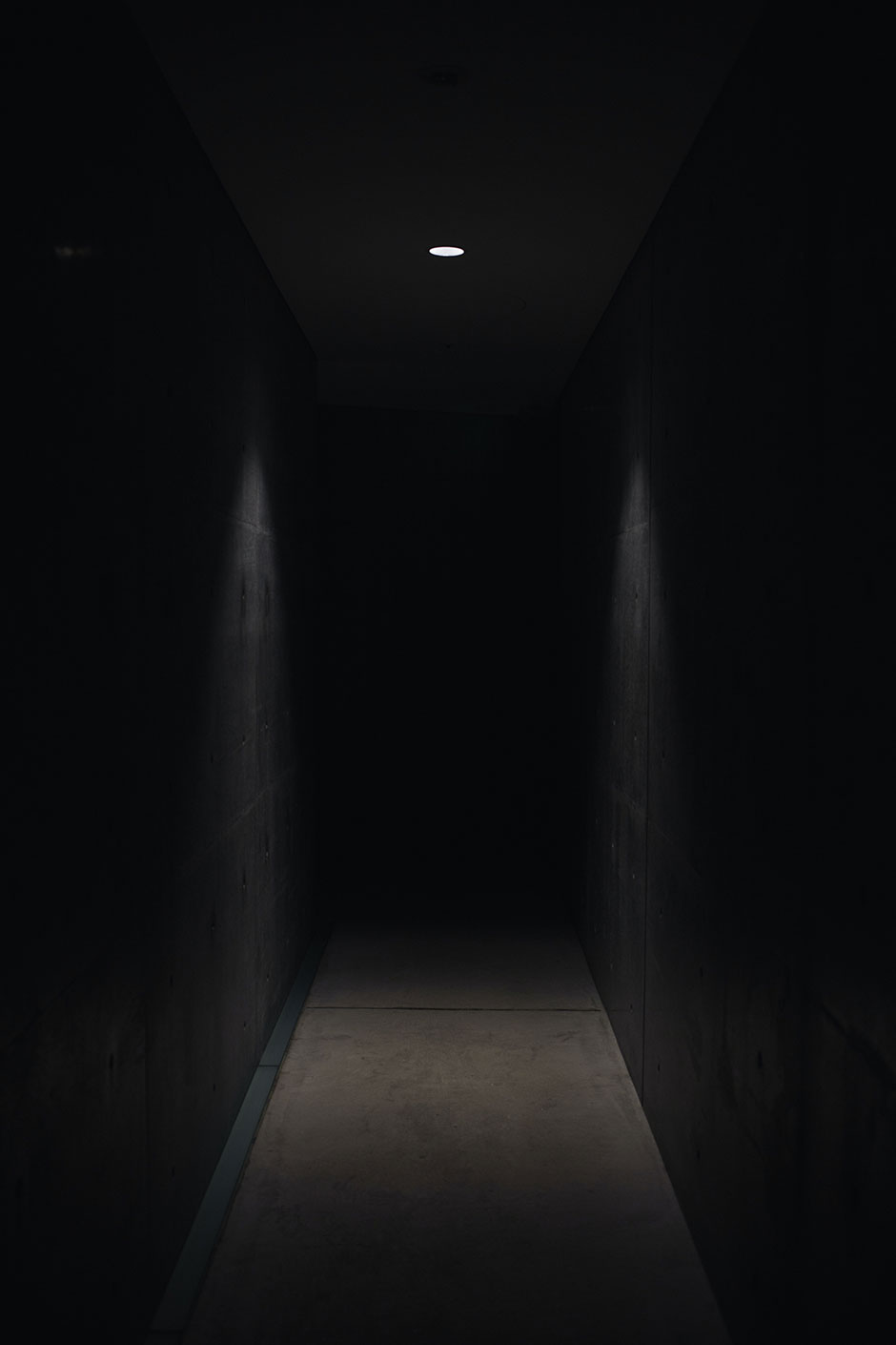 Un corridoio illuminato in parte e buio in fondo.